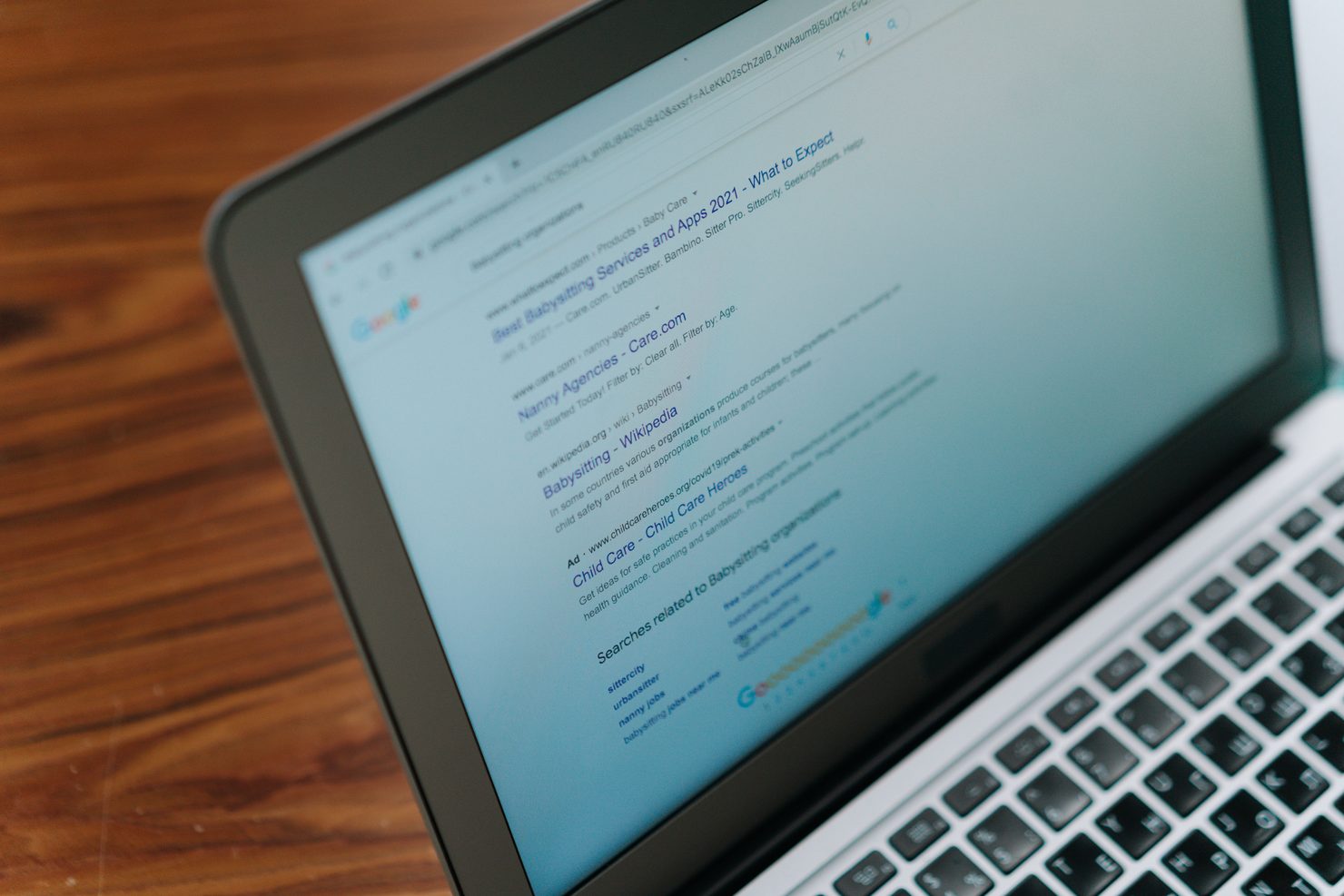 A laptop screen showing a page of Google search results, with several businesses listed one after another