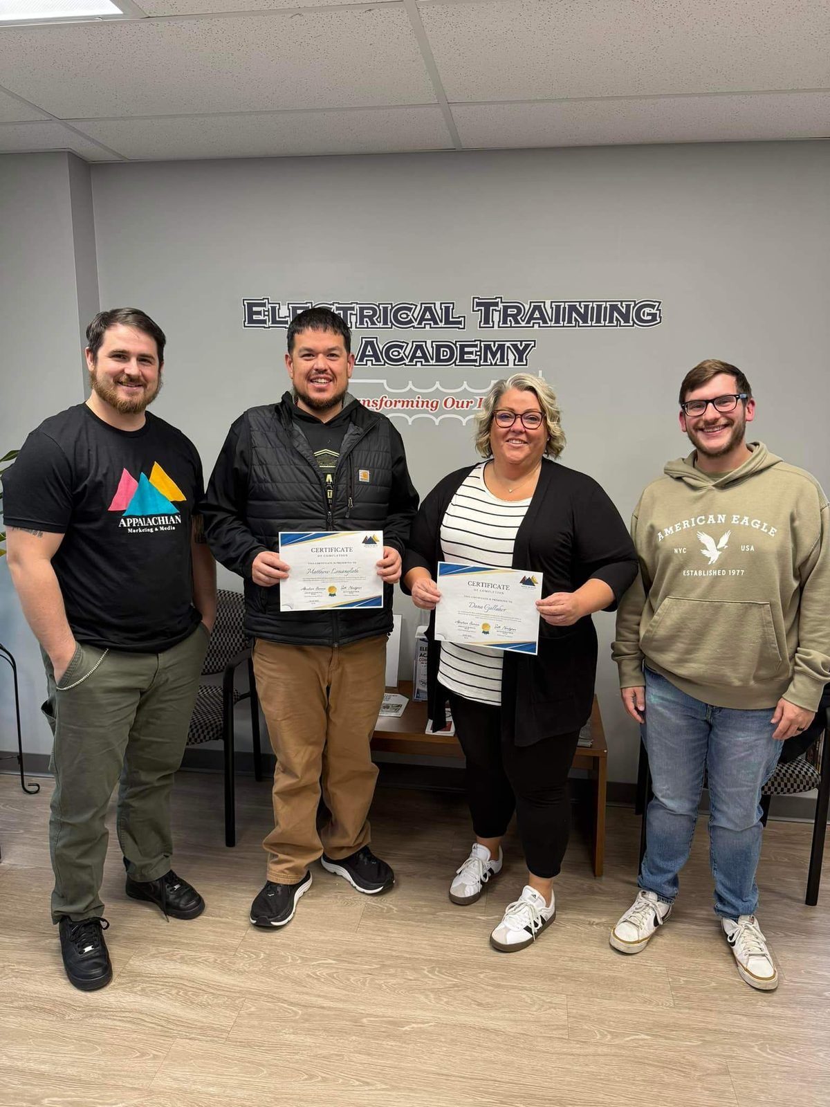 Training participants holding their certificates alongside AMM instructors
