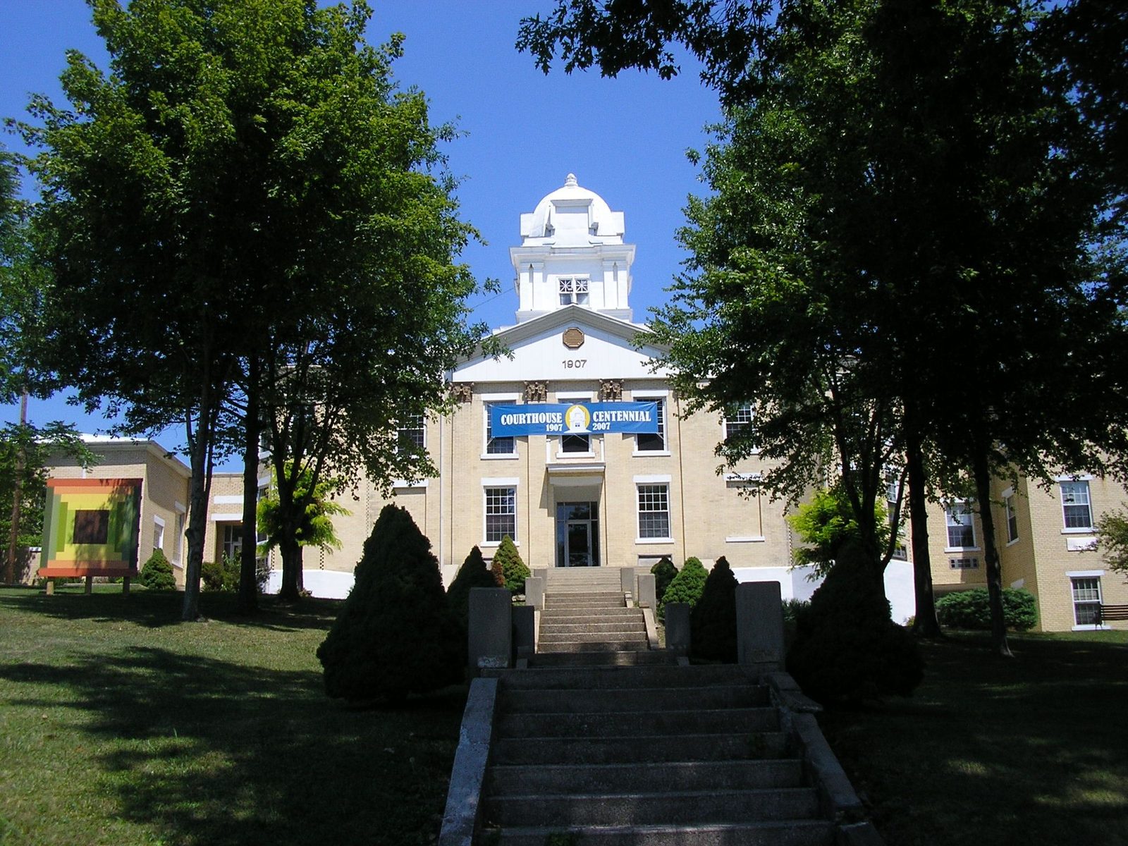 The historic 1907 Carter County Courthouse in Grayson, Kentucky framed by mature trees