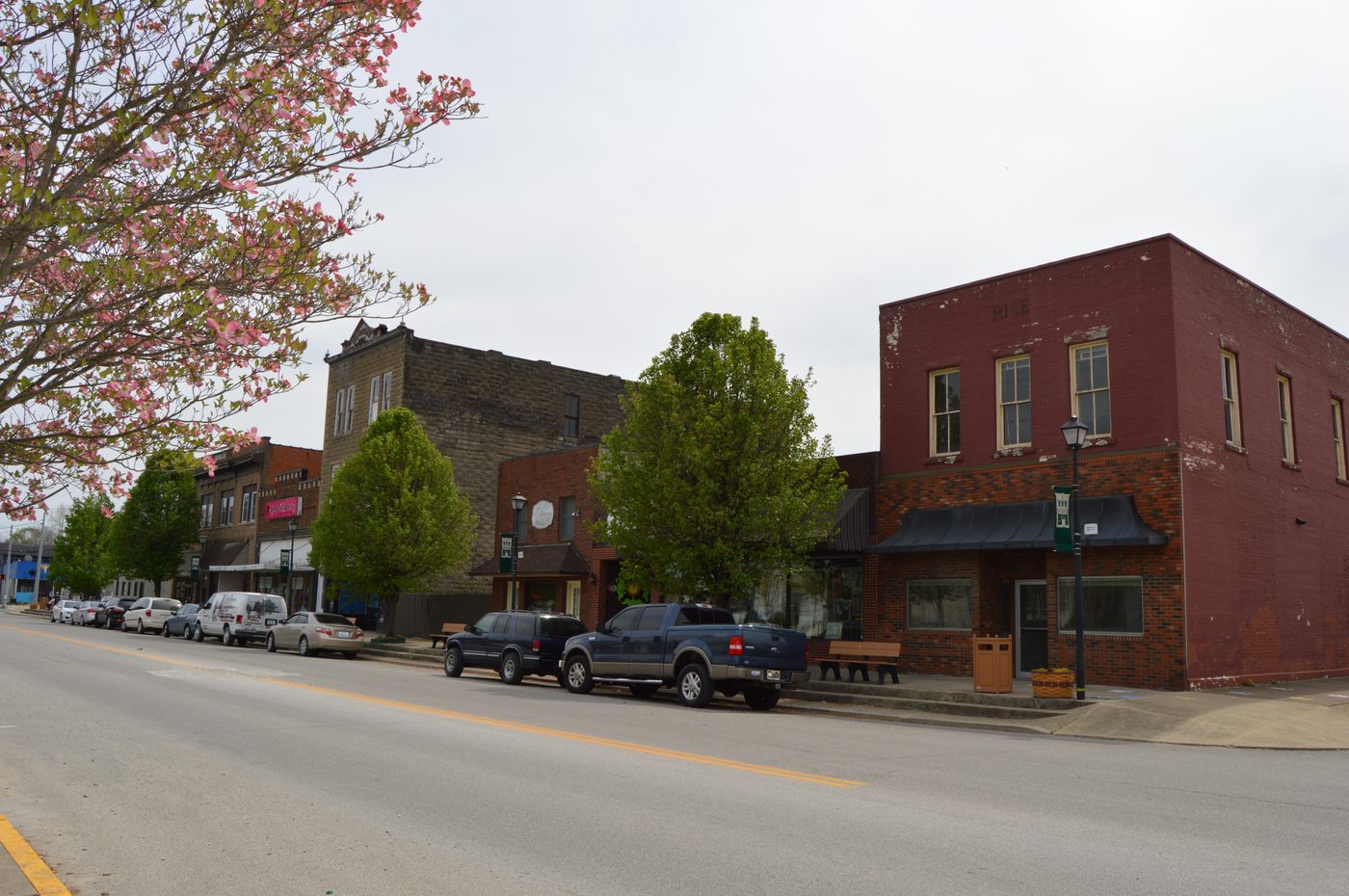Main Cross Street in historic downtown Louisa, Kentucky with local shops and Appalachian hills in the distance
