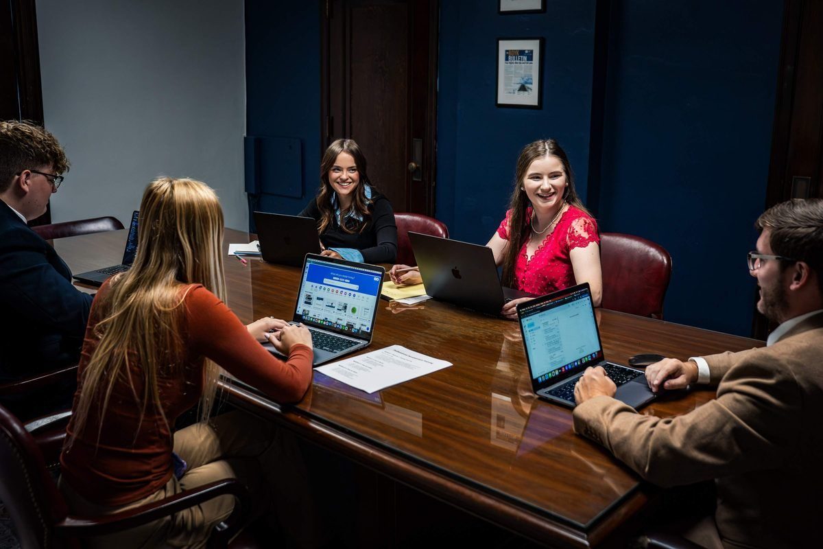 Appalachian Marketing & Media strategy team meeting around laptops