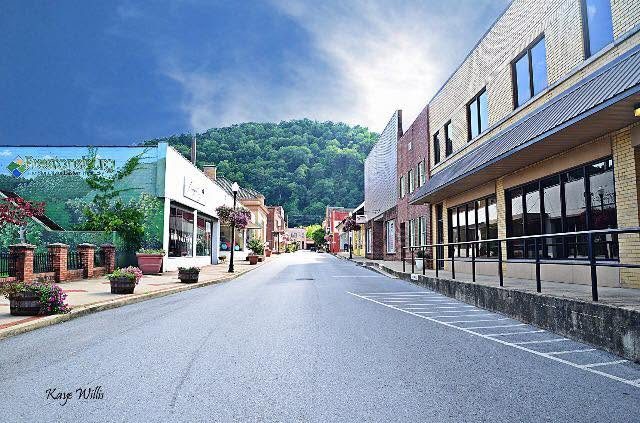 Main Street in historic downtown Prestonsburg, Kentucky with local shops and Appalachian hills in the distance