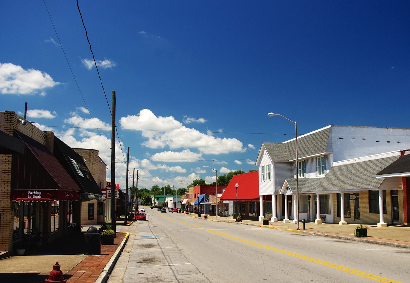 Main Street in downtown Russell, Kentucky with local shops and Appalachian hills in the distance